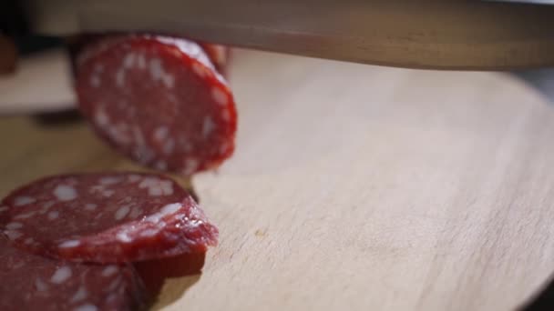 Mão especialista corta Parma temperada salame, em fatias finas com uma faca e emana o sabor eo sabor italiano — Vídeo de Stock