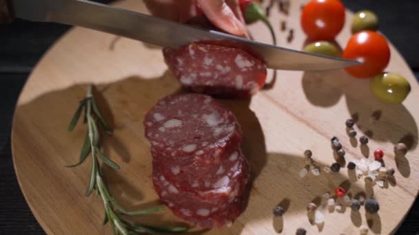 Mão especialista corta Parma temperada salame, em fatias finas com uma faca e emana o sabor eo sabor italiano — Vídeo de Stock