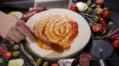 Sos ekliyorum. İtalyan pizza hazırlığı. Çerçeve.