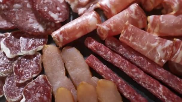 Salami and chorizo sausage close up on stone serving board — Stock Video