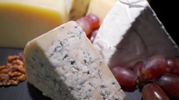 Sortiment předkrmů, předkrmů nebo gurmánských večeří. Top view, close distance, a wedge of cheese, on a rare, wooden plate, degustace francouzského vína. — Stock video