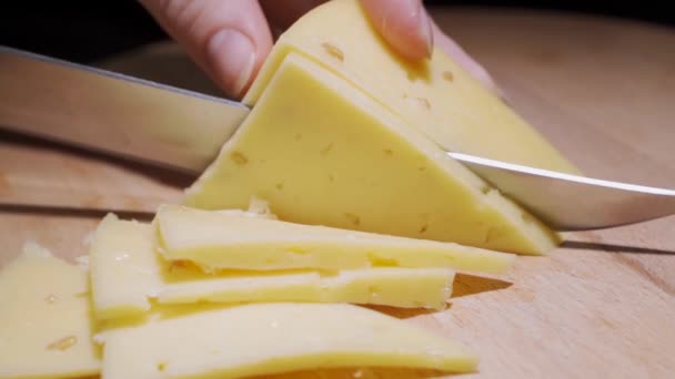 Närbild av kvinnliga kock eller hemmafru skära ost med en kniv, slow motion. — Stockvideo