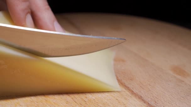 Kemény francia sajt fapadlóra vágva — Stock videók