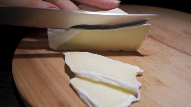 여성 요리사나 주부가 나이프로 치즈를 천천히 자르는 모습 — 비디오