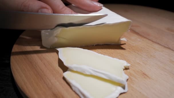 Composition du fromage italien, sur une planche à découper en bois. Une main prend le couteau et casse quelques morceaux pour savourer la qualité. — Video