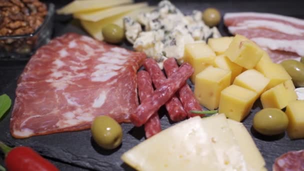 Platter com presunto espanhol jamon serrano ou italiano prosciutto crudo, fatiado italiano queijo duro pecorino toscano, salame de carne seca caseira com avelãs, amêndoas, queijo azul, maionese, — Vídeo de Stock