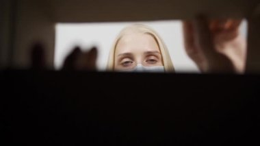 Mutlu kadın teslimatı alışveriş kutusunda açıyor, gülümseyen kadın e-ticaret kıyafetlerinin içine bakıyor.