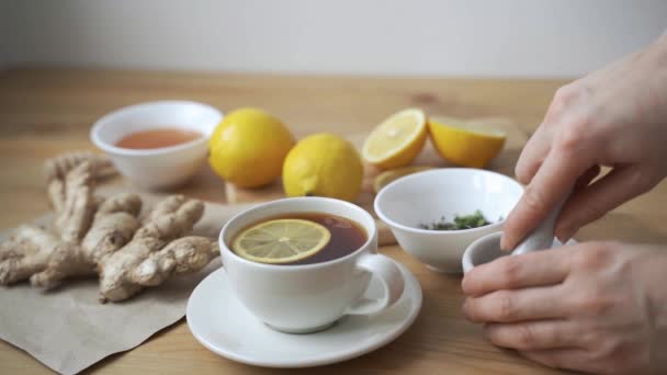 Чашка здорового чая с различными видами сушеных трав и цветов — стоковое видео
