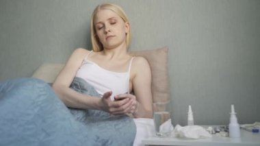 Birleşik Devletler 'de yeni Coronavirus COVID-19 dalgası. COVID-19 için ev tedavisi. Genç bir kadın koronavirüs belirtileriyle yatakta yatıyor..