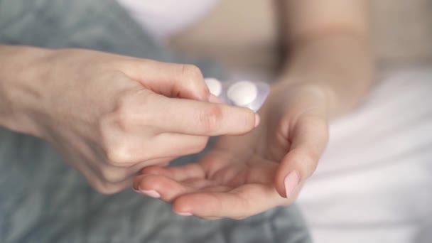 Zeitlupenaufnahme von Frauenhänden, die Medikamententabletten aus einer Blisterverpackung nehmen. — Stockvideo