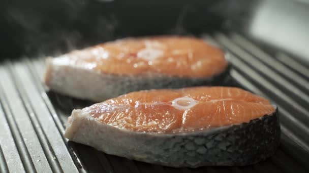 O filete do peixe vermelho frita-se em uma panela. Frutos do mar. Preparação de salmão. — Vídeo de Stock