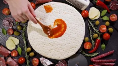 Pizza üssü. Yukarıdan bak. Sosu pizza tabanına sürün. Evde pişir..