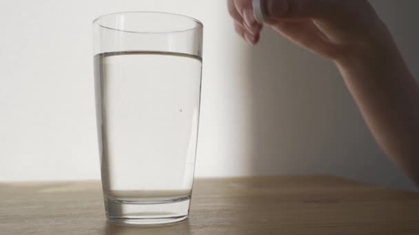 Close up of effervescent tablet dissolves into glass of water. Aspirin, paracetamol, painkiller and antipyretic. Coronavirus, flu, cold, covid 19 — Stock Video