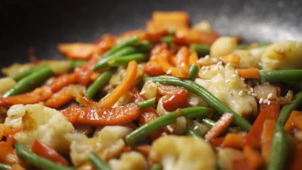 Femme préparant un mélange de légumes asiatiques - frites de légumes à l'huile, saupoudrer de graines de sésame — Video