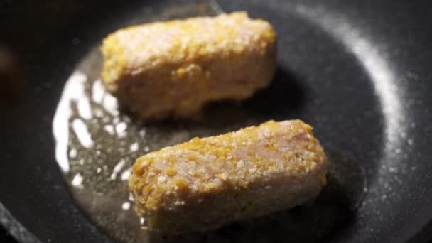 Pierś kurczaka jest gotowana jako smażony kurczak z patelnią i długimi drewnianymi pałeczkami. Dodać jajka i okruszki chleba i piec w oleju. — Wideo stockowe