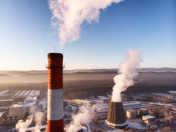 İki fabrika bacasından çıkan dumandan kaynaklanan hava kirliliği. Şehirde sanayi bölgesi. hava görünümü
