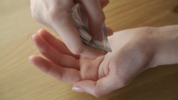Крупный план рук женщины, которая хочет извлечь таблетку из пузыря — стоковое видео