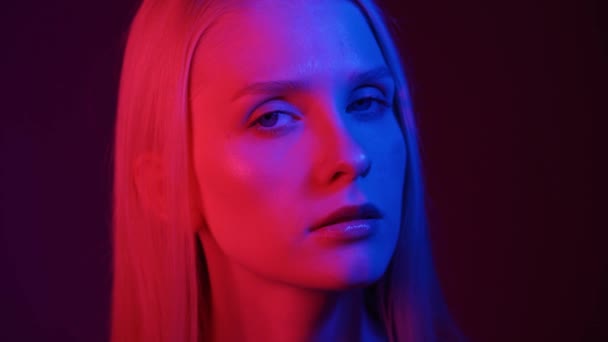 Portrait of a young woman in neon light. Colored light in the club, fashion portrait — Stock Video