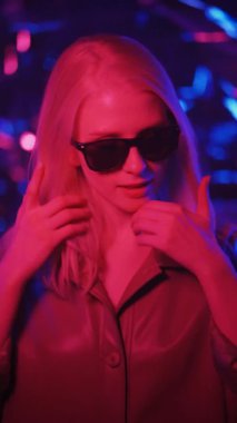 Neon ışıklı manken kadın, floresan makyajlı güzel model kız, yavaş çekim video görüntüleri. Dikey görüntüler