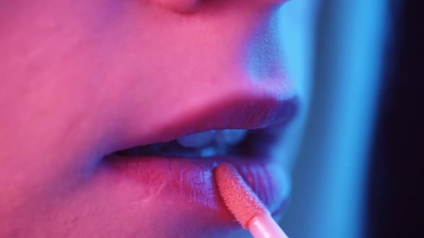 Primeros planos de una hermosa chica que se pone maquillaje Neon UV en la boca, labios y ojos antes de salir a un club. — Vídeo de stock