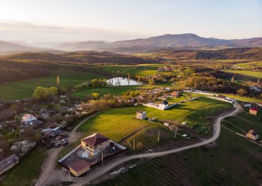 Yeşil tarlalar ve tepelerin arasında küçük bir köy. Kırsal yaşam.