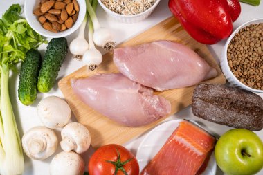 Protein Menüsü: Et, Taze Sebze, Meyve ve Fındık. Beyaz taş arka planda sağlıklı yiyecekler