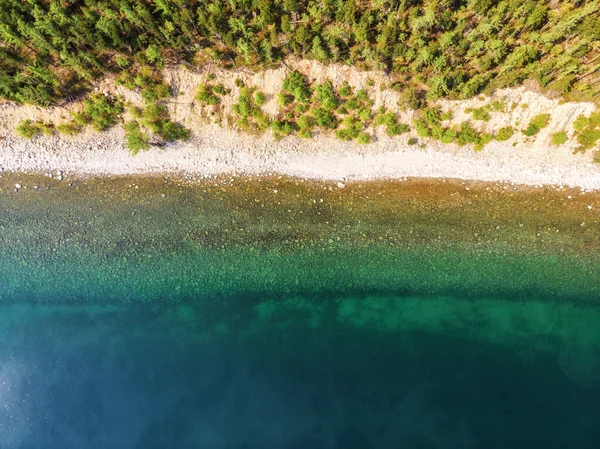 stock image Beautiful view of the sandy shore of the lake, on the horizon of the mountain, larch, pines