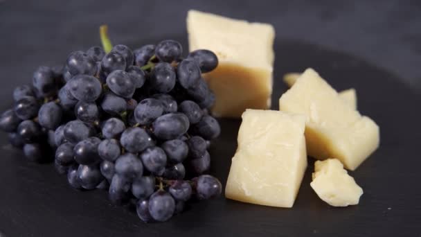 Il Parmigiano Gourmet viene servito su un piatto di pietra nera con noci e uva — Video Stock