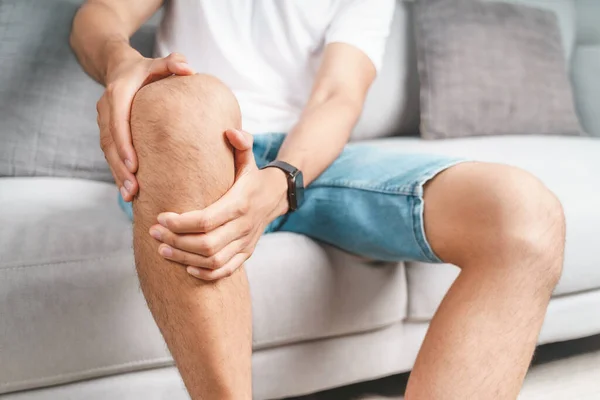 Man Met Kniepijn Die Bank Zit Zijn Pijnlijke Knie Masseert — Stockfoto