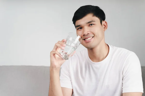 Schöner Asiatischer Mann Trinkt Ein Glas Wasser Auf Dem Sofa — Stockfoto