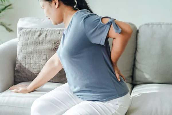 Dojrzała Kobieta Czuje Ból Plecach Siedząc Kanapie Domu Opieka Zdrowotna — Zdjęcie stockowe