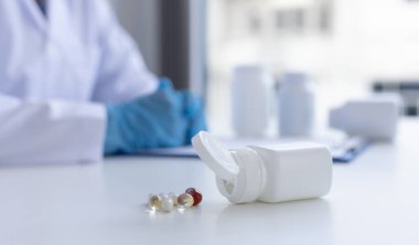 Yakın plan portre, beyaz laboratuvar önlüklü bilim adamları, tedavi konsepti için tıp bilimadamı olan bir laboratuarda örnek ilacın hayati bileşenlerini analiz ediyorlar.. 