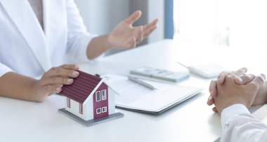 Emlakçılar müşterilerine sigortalı bir ev alma kararı almalarını öneriyor. Satın alma ve yatırım planlama konsepti pazarlığı.