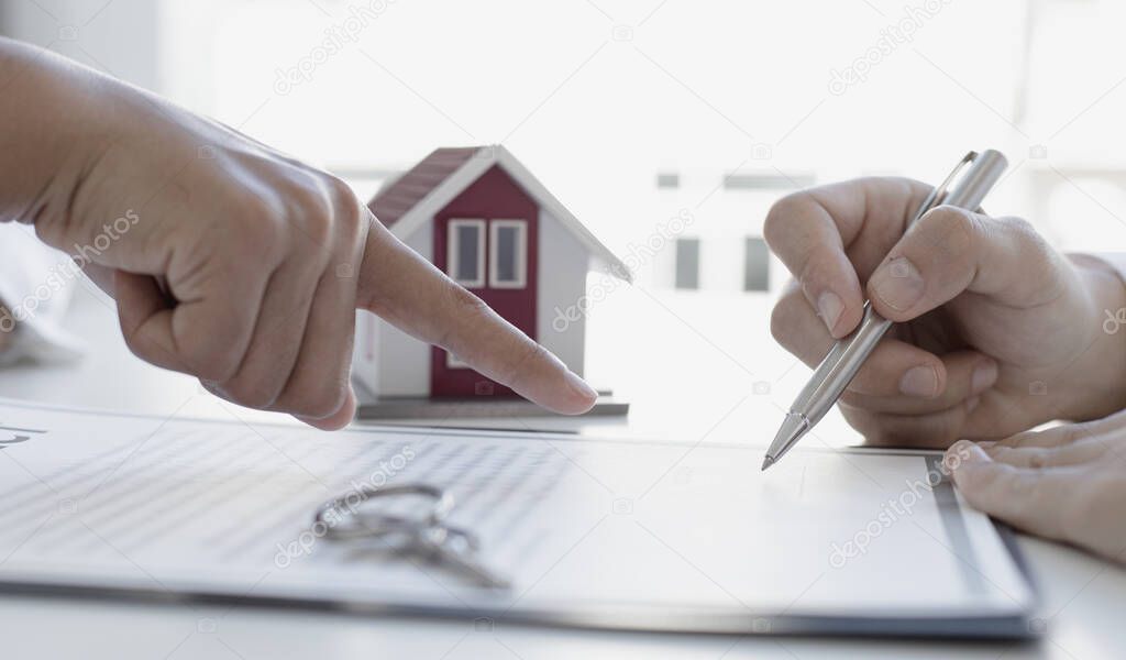 Real estate agent or sales manager has proposed terms and conditions to customers who sign house purchase agreements with insurance, Agreement to sign the purchase contract concept.