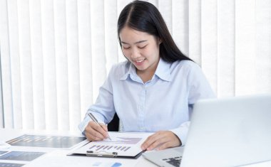 Asya 'daki pazarlama şefi şirketin finansal büyüme grafiğini analiz ediyor. Kişisel bilgisayarları iş için kullanıyor, ev kavramı üzerine çalışıyor..