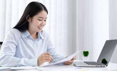 Asya 'daki pazarlama şefi şirketin finansal büyüme grafiğini analiz ediyor. Kişisel bilgisayarları iş için kullanıyor, ev kavramı üzerine çalışıyor..