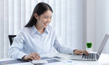 Asya 'daki pazarlama şefi şirketin finansal büyüme grafiğini analiz ediyor. Kişisel bilgisayarları iş için kullanıyor, ev kavramı üzerine çalışıyor..