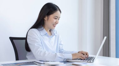 Asya 'daki pazarlama şefi şirketin finansal büyüme grafiğini analiz ediyor. Kişisel bilgisayarları iş için kullanıyor, ev kavramı üzerine çalışıyor..