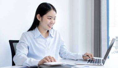 Asya 'daki pazarlama şefi şirketin finansal büyüme grafiğini analiz ediyor. Kişisel bilgisayarları iş için kullanıyor, ev kavramı üzerine çalışıyor..