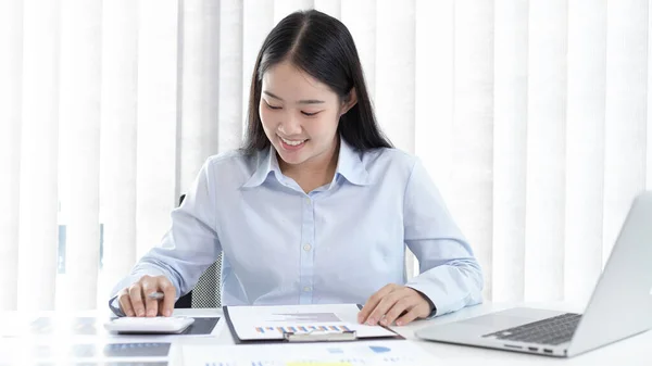 Chief marketing officer in Asia is analyzing the company's financial growth graph using personal computers for work, Working at home concept.