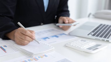 Finans işkadınları pazarlama stratejilerini ve emlak verilerini analiz etmek için dizüstü bilgisayar ve akıllı telefon kullanarak müşterileri, Muhasebe ve Vergi kavramlarının şirket vergilerini düşürürler..