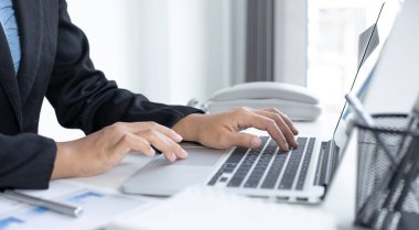 Finans işkadınları, pazarlama stratejileri ve emlak verilerini analiz etmek için dizüstü bilgisayar kullanarak müşterileri, muhasebe ve vergi kavramlarının şirket vergilerini düşürürler..