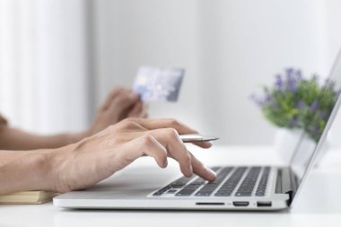 Erkekler internet üzerinden kredi kartı ödemelerini, teknoloji ve İnternet 'te rahatlığı, online alışveriş ve çevrimiçi bankacılık kavramını kullanarak çevrimiçi alışverişleri kaydetmek için dizüstü bilgisayar kullanıyorlar.