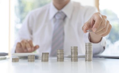 Para biriktirmeye para yatıran işadamı, ticari yatırımın finansal büyüme kârını, gerektiğinde kullanım için para yönetimini, tasarruf ve yatırım kavramını gösteren bir grafiği gösteriyor.
