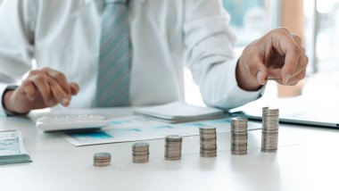 Para biriktirmeye para yatıran işadamı, ticari yatırımın finansal büyüme kârını, gerektiğinde kullanım için para yönetimini, tasarruf ve yatırım kavramını gösteren bir grafiği gösteriyor.