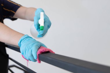 Genç Asyalı erkek çalışanlar parmaklıkları veya verandayı temizlemek, virüs salgınları sırasında patojen önleme veya temizlik yapmak, bir restoranı veya kahve dükkanını temizlemek için alkole bulanmış bir havlu kullanıyorlar..
