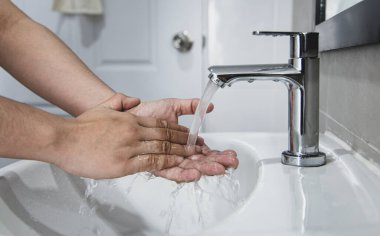 Erkekler, solunum bakterilerini, virüsleri temizlemek için lavaboda ellerini yıkıyor ve COVID-19 'un tüm dünyaya yayılmasını, hijyen ve sağlık hizmetleri kavramını azaltıyor..