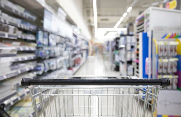 Shopping cart in supermarket, Abstract blurred photo in shopping malls, Cart in the market, wide variety of products are placed on the shelves for an orderly display.