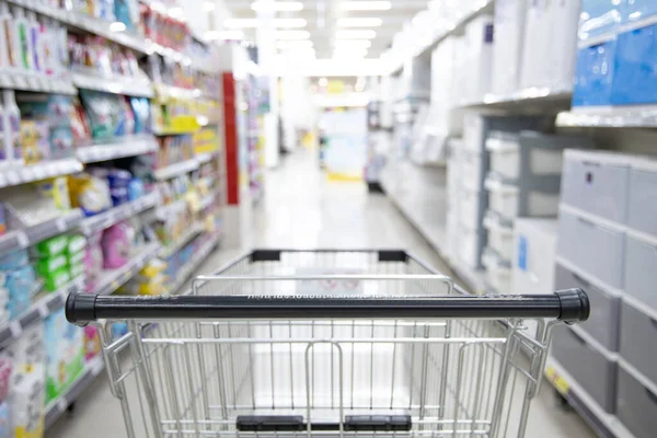 Shopping cart in supermarket, Abstract blurred photo in shopping malls, Cart in the market, wide variety of products are placed on the shelves for an orderly display.