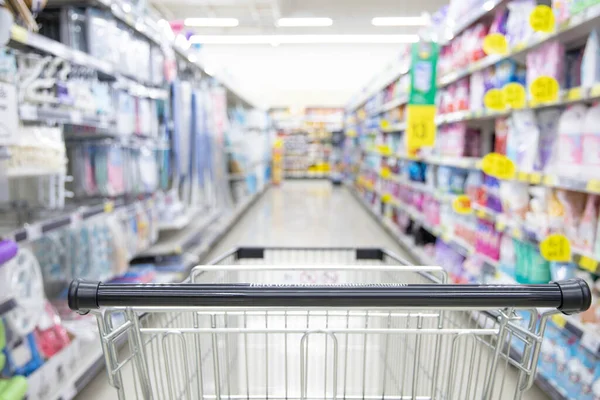 Shopping cart in supermarket, Abstract blurred photo in shopping malls, Cart in the market, wide variety of products are placed on the shelves for an orderly display.